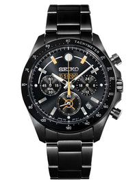 A Seiko chronograph watch with a black stainless steel case and link bracelet, featuring a black dial with gold-tone hands, markers, and subdials.