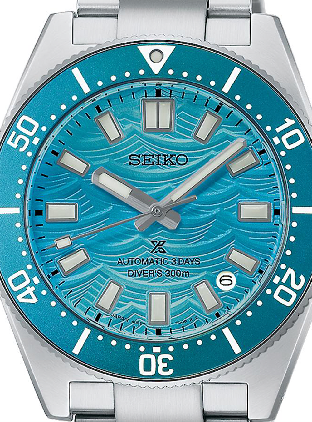 A close-up of a Seiko dive watch with a silver stainless steel case and bracelet, featuring a vibrant turquoise blue dial with a wavy pattern and a matching blue bezel.