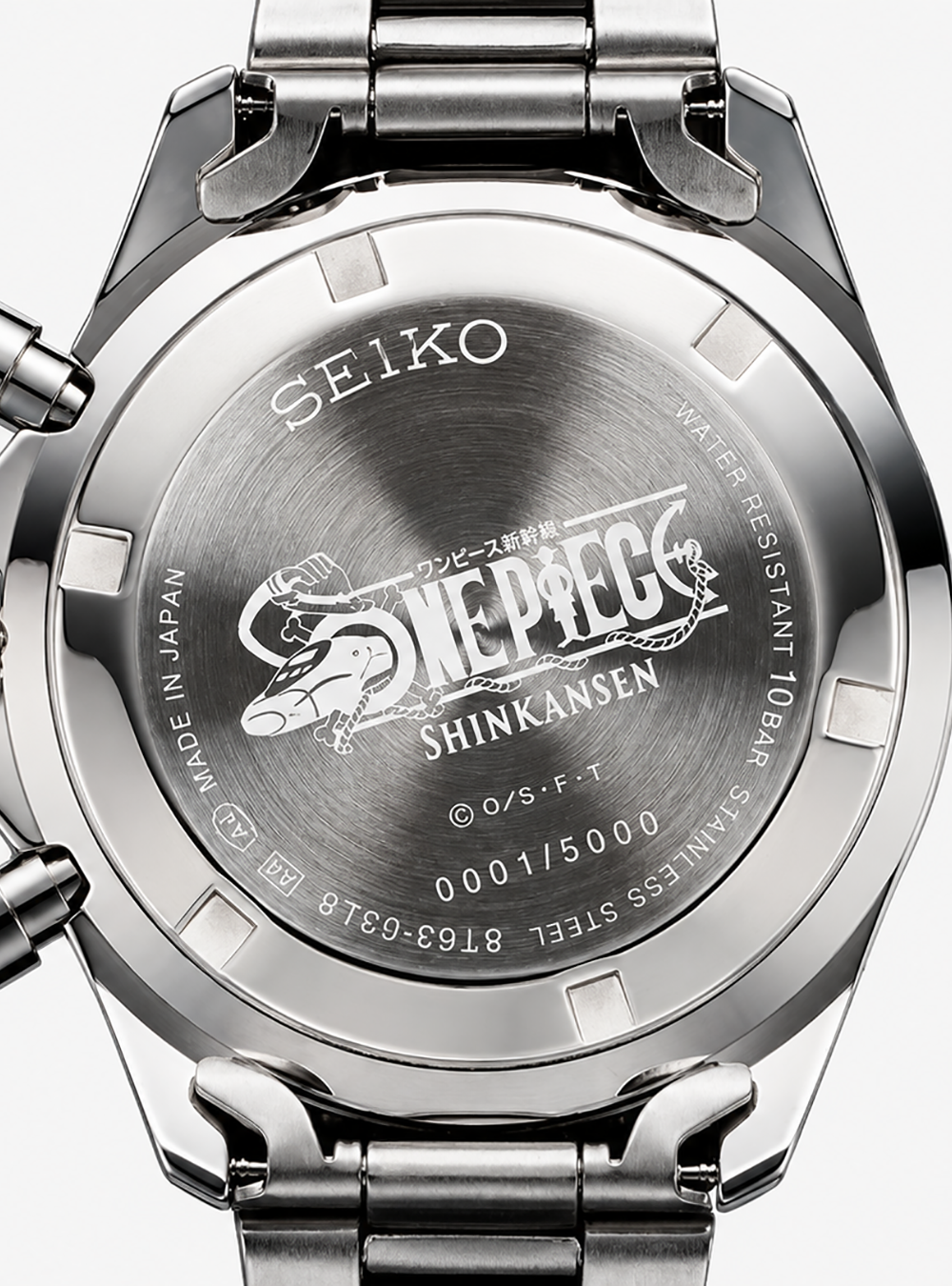 Close-up of the back of a stainless steel Seiko watch with a metal link band, showing engraved text and the One Piece Shinkansen logo on the case.