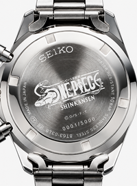 Close-up of the back of a stainless steel Seiko watch with a metal link band, showing engraved text and the One Piece Shinkansen logo on the case.