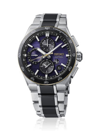 A Seiko Astron chronograph watch with a silver titanium case and link bracelet, featuring a black bezel and a blue-purple sunburst dial with gold accents.