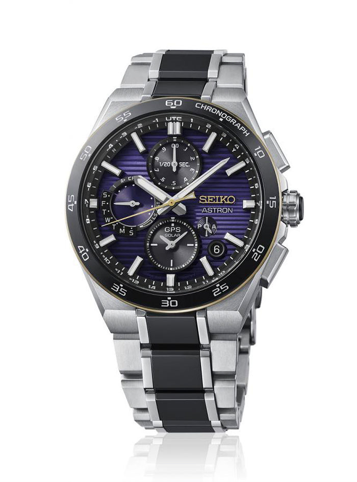 A Seiko Astron chronograph watch with a silver titanium case and link bracelet, featuring a black bezel and a blue-purple sunburst dial with gold accents.