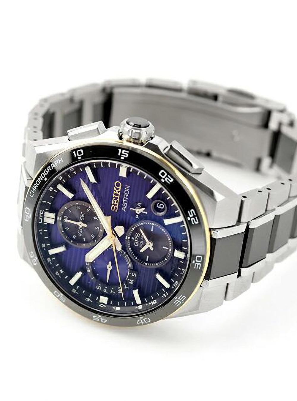 A Seiko Astronom chronograph watch with a silver titanium case and link bracelet, featuring a deep blue sunburst dial with gold-tone accents and subdials.