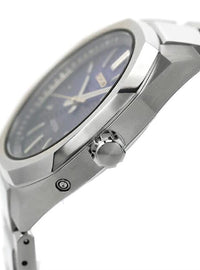 Close-up of a titanium wristwatch with a dark blue dial and matching blue accents, featuring a prominent crown and a date window.