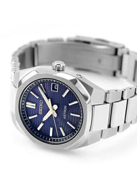 A Seiko Astron watch with a silver titanium case and bracelet, featuring a deep blue sunburst dial with silver-tone indices and hands.