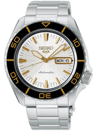 The dial features a bright, clean white finish with a delicate pattern radiating from the center. As it catches the light, its appearance shifts, adding depth to the understated design. Yellow-gold-tone indices, hour and minute hands, and the SEIKO logo create an elegant contrast against the white dial.