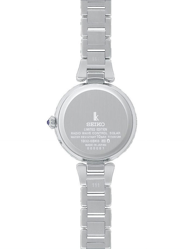 The back of a silver Seiko women's watch with a titanium link bracelet, featuring a round case with engraved details and a crown adjustment knob on a white background.